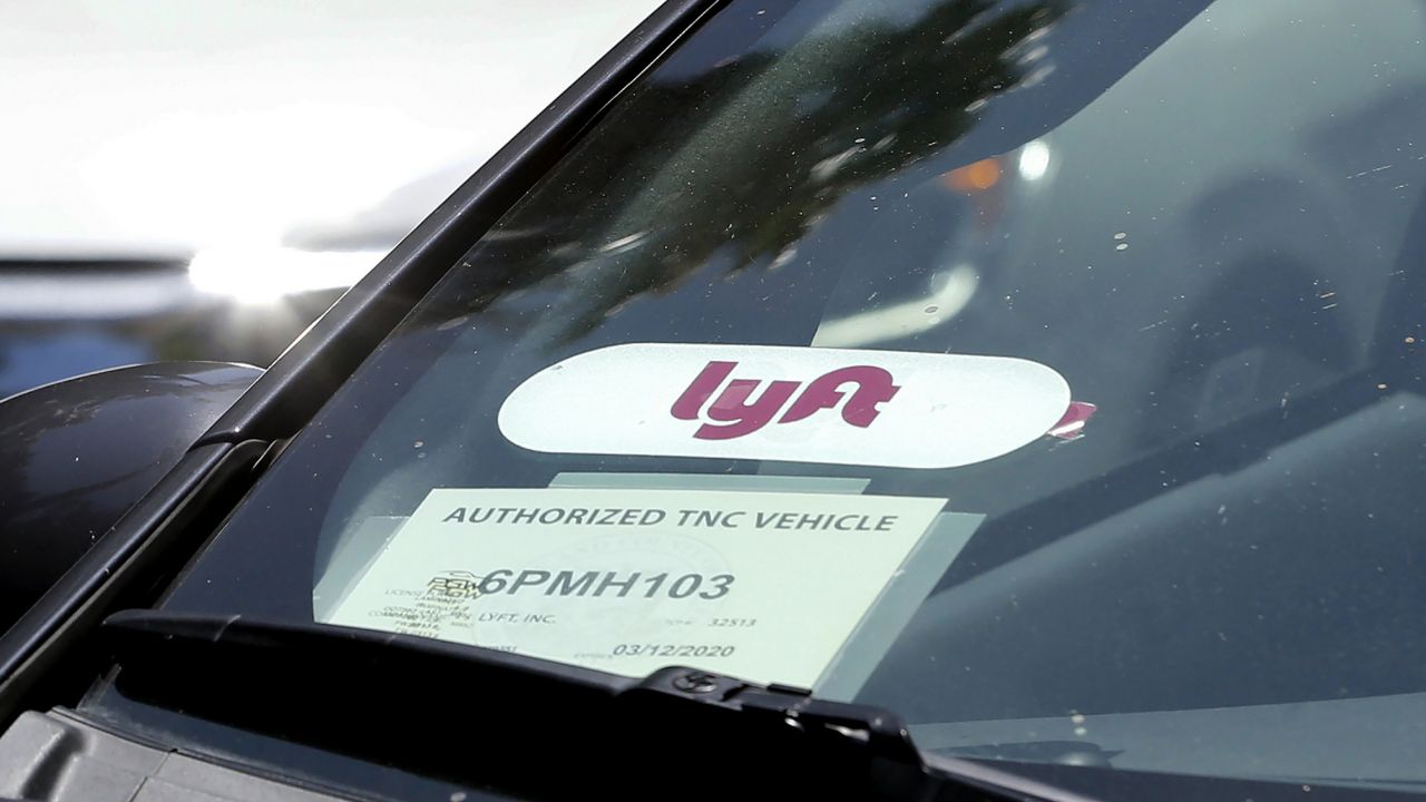 FILE - In this July 9, 2019, file photo a Lyft ride-share car waits at a stoplight in Sacramento, Calif. (AP Photo/Rich Pedroncelli, File)