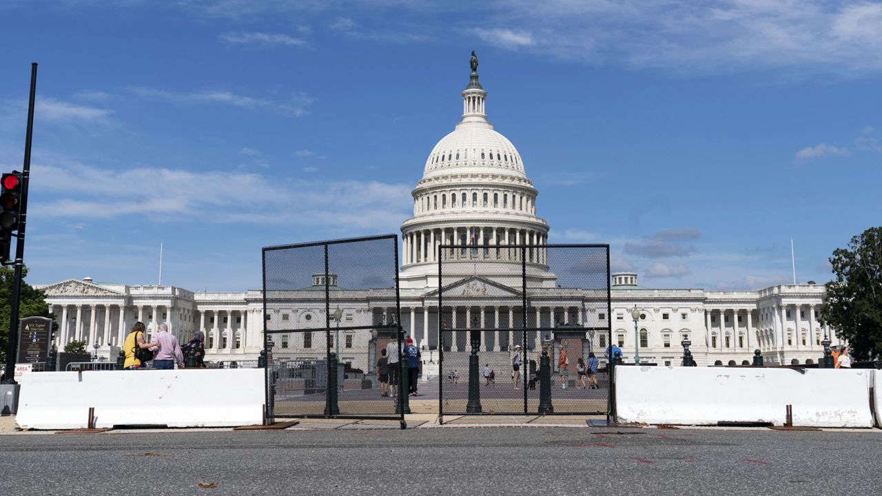 FILE: People walk to the U.S. Capitol as workers remove the fence surrounding the U.S. Capitol building, after six months was erected, following the Jan. 6 riot at the Capitol, on Saturday, July 10, 2021, in Washington. (AP Photo/Jose Luis Magana)