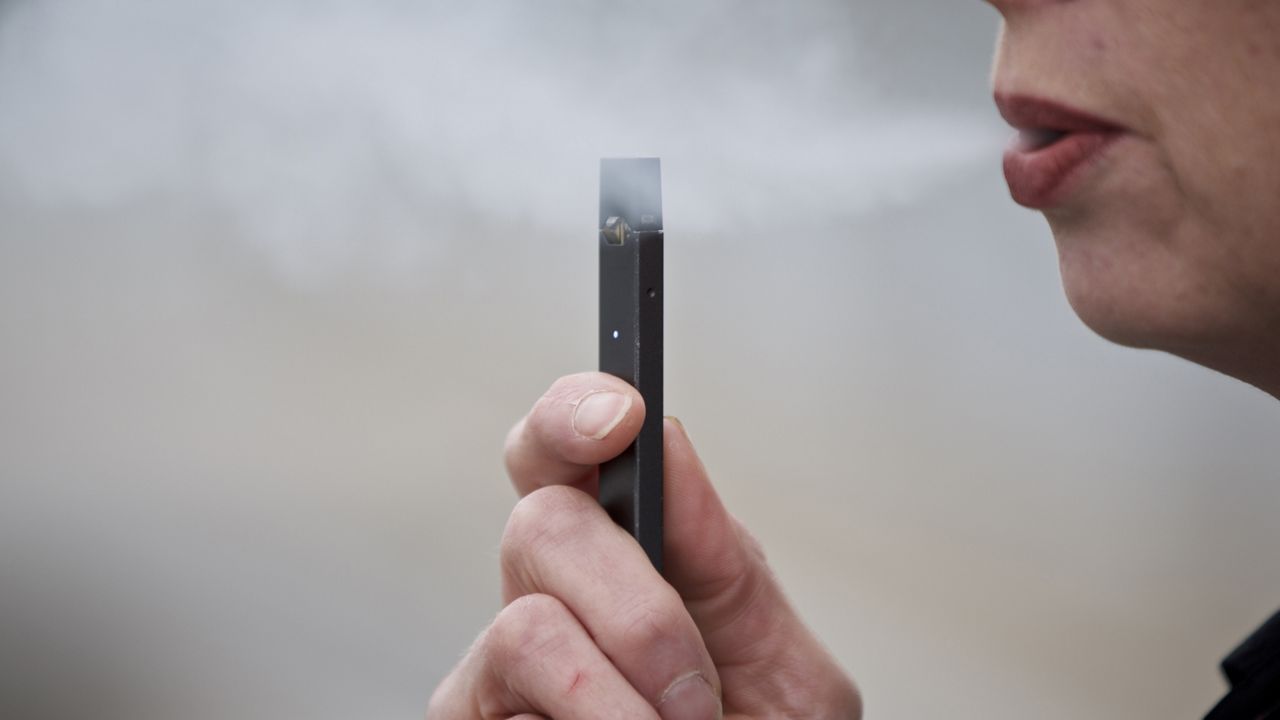 FILE - A woman exhales a puff of vapor from a Juul pen in Vancouver, Wash. (AP Photo/Craig Mitchelldyer, File)