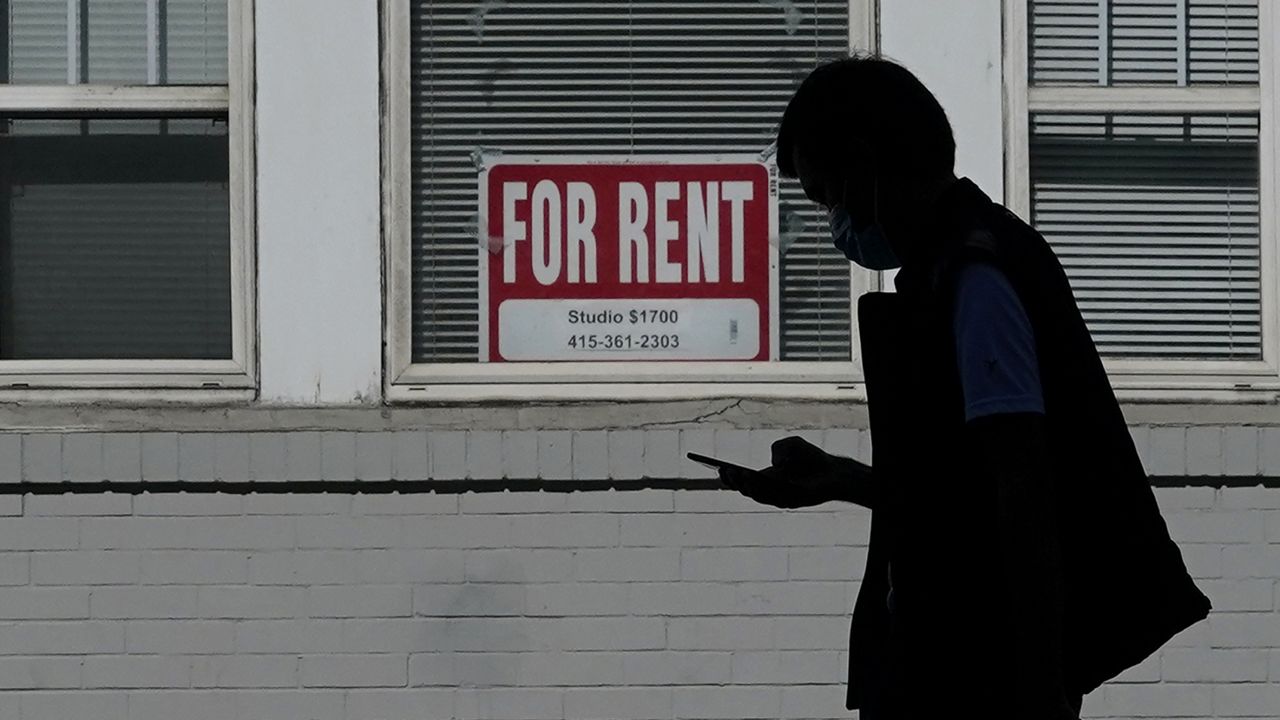 FILE - A man walks in front of a For Rent sign in a window of a residential property in San Francisco. (AP Photo/Jeff Chiu, File)