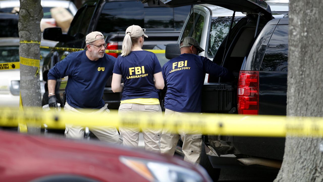 FILE: Members of the FBI load equipment into a vehicle as they work in a parking lot outside a municipal building that was the scene of a shooting, Saturday, June 1, 2019, in Virginia Beach, Va. (AP Photo/Patrick Semansky)