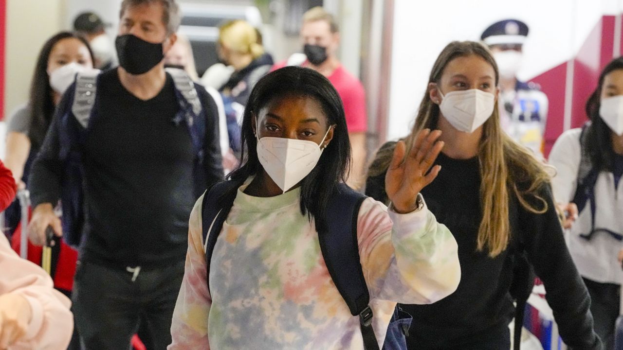 FILE: Simone Biles, center, and the U.S. Women's Gymnastics team arrive for the Tokyo 2020 Summer Olympic Games at Narita International Airport Thursday, July 15, 2021. (AP Photo/Kiichiro Sato)