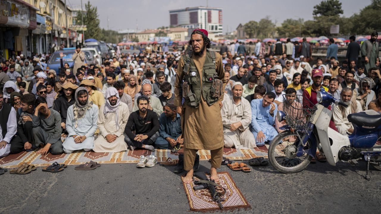 FILE: A Taliban fighter, foreground, and a group of Afghan men attend Friday prayers in Kabul, Afghanistan, Friday, Sept. 24, 2021. (AP Photo/Bernat Armangue)