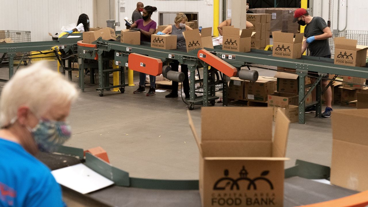Volunteers pack boxes of food for distribution, at The Capital Area Food Bank, Tuesday, Oct. 5, 2021, in Washington. (AP Photo/Jacquelyn Martin)