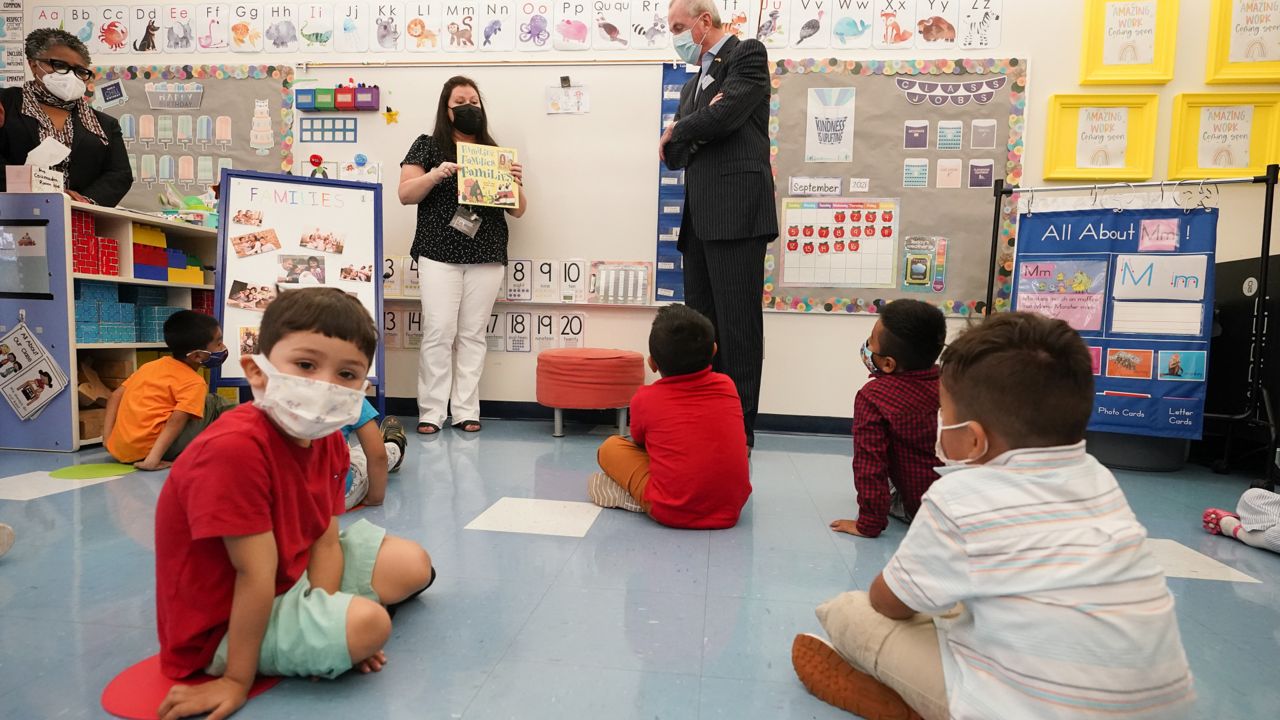 FILE: Acting Department of Education Commissioner Angelica Allen-McMillan, left, looks on as New Jersey Gov. Phil Murphy, right, talks to pre-K teacher Vera Csizmadia, center, in her classroom. (AP Photo/Mary Altaffer)