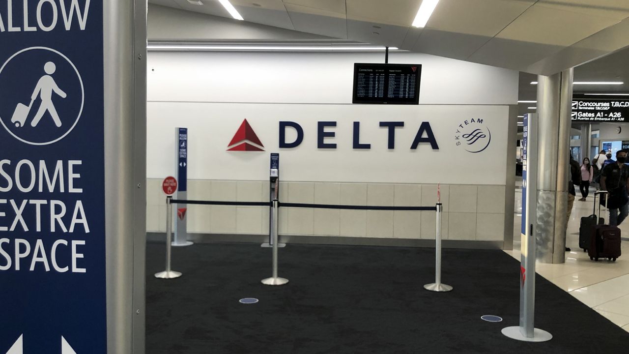 FILE: People move through a terminal at Hartsfield-Jackson Atlanta International Airport, Tuesday, Oc. 13, 2020, in Atlanta. (AP Photo/Mike Stewart)