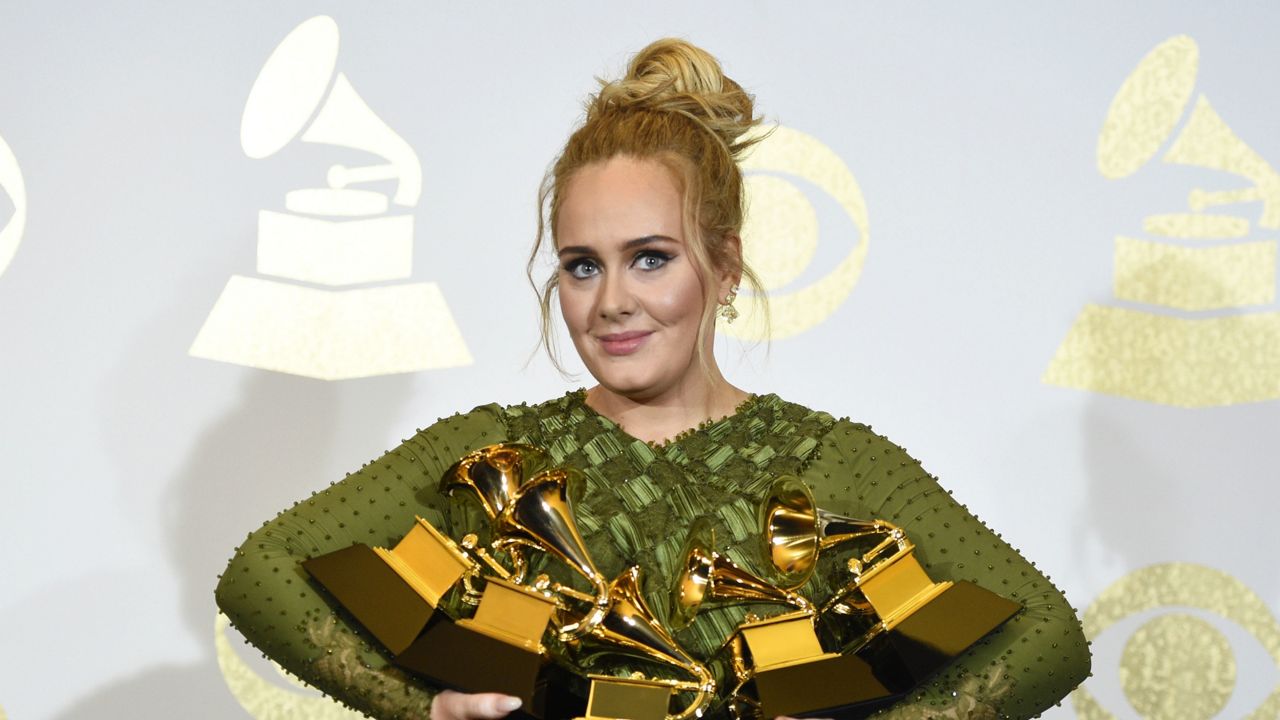 FILE - Adele poses in the press room with her awards for her album "25" at the Grammy Awards in Los Angeles on Feb. 12, 2017. (Photo by Chris Pizzello/Invision/AP, File)
