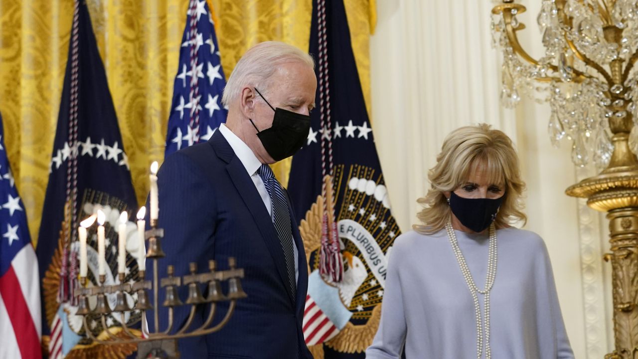 President Joe Biden and first lady Jill Biden walk past the lit menorah following an event in the East Room of the White House in Washington, to celebrate Hanukkah, Wednesday, Dec. 1, 2021. (AP Photo/Susan Walsh)