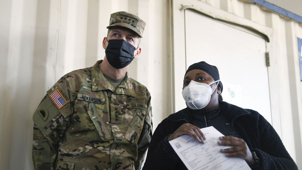 FILE: Army Gen. Dan Hokanson, chief of the National Guard Bureau, talks with a public health official during a visit to a COVID-19 vaccination site. (Sgt. 1st Class Jim Greenhill/U.S. Army National Guard via AP)