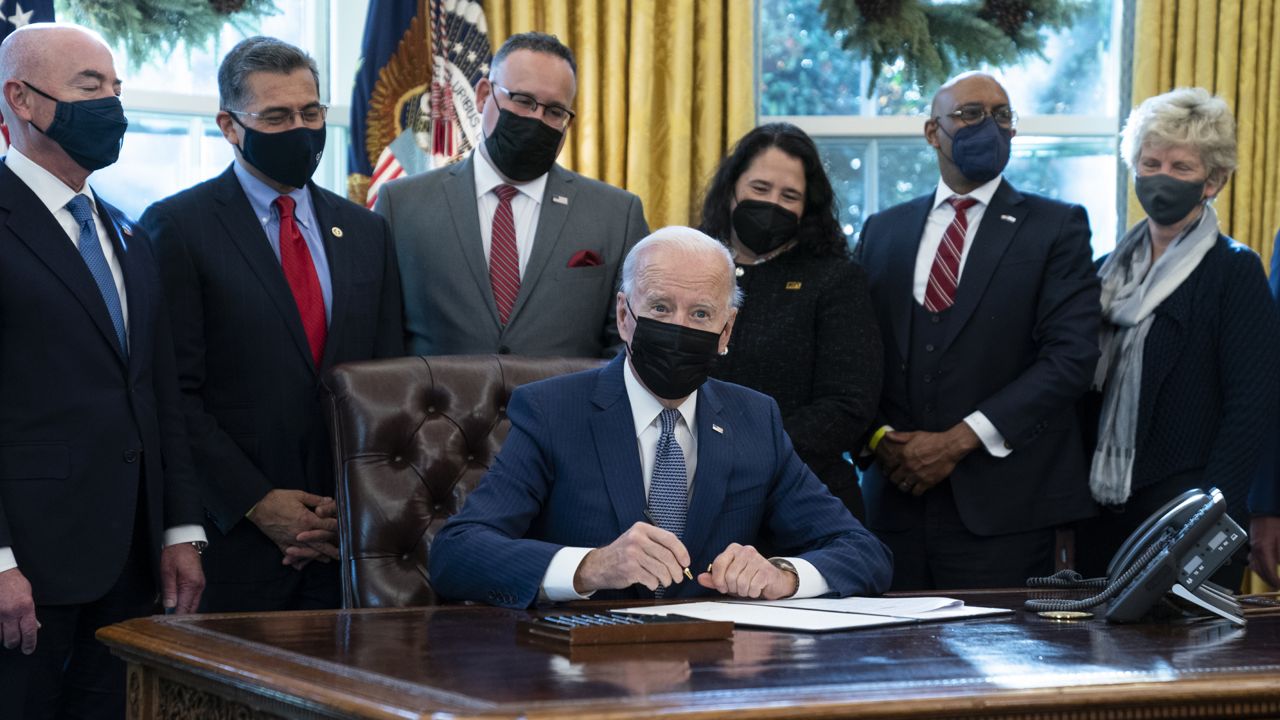 President Joe Biden signs an executive order to improve government services, in the Oval Office of the White House, Monday, Dec. 13, 2021, in Washington. (AP Photo/Evan Vucci)