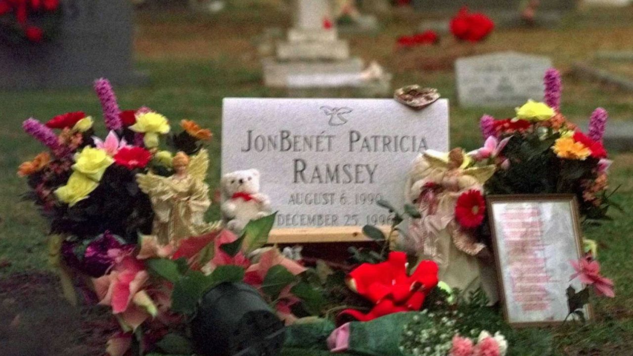 FILE - Flowers, pictures and stuffed animals adorn the gravesite of JonBenet Patricia Ramsey on Dec. 26, 1997. (AP Photo/Ric Feld, File)