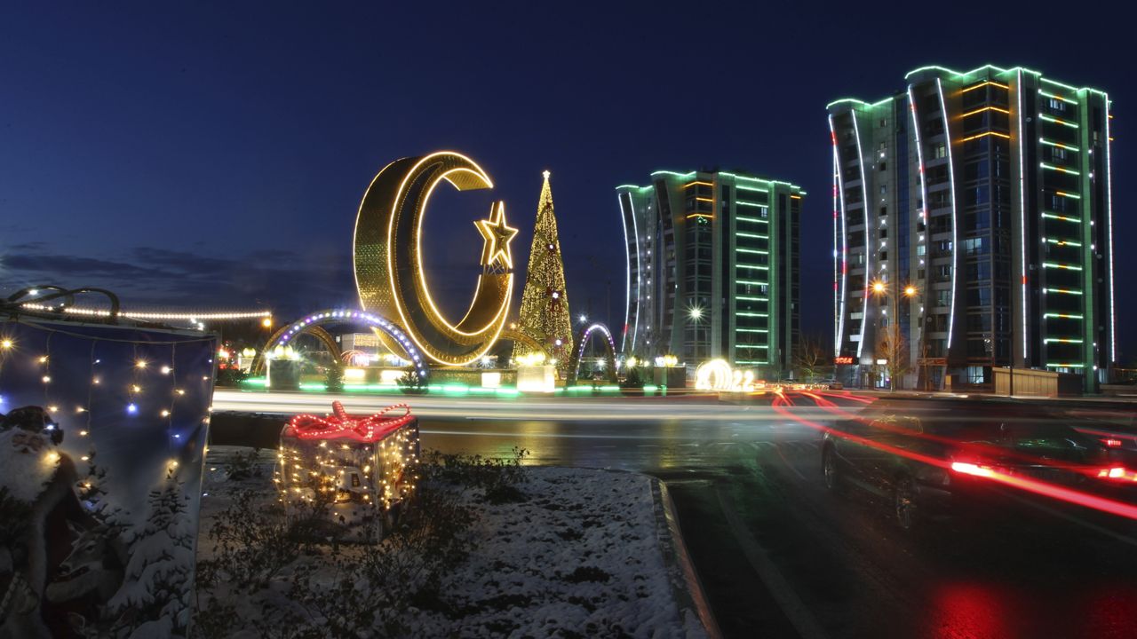 A Christmas tree, a crescent and apartments buildings decorated for New Year celebrations are seen at the central square in Argun, about 17 km. (11 miles) east of Grozny, the capital of Chechen republic, Russia, Thursday, Dec. 23, 2021. (AP Photo/Musa Sadulayev)