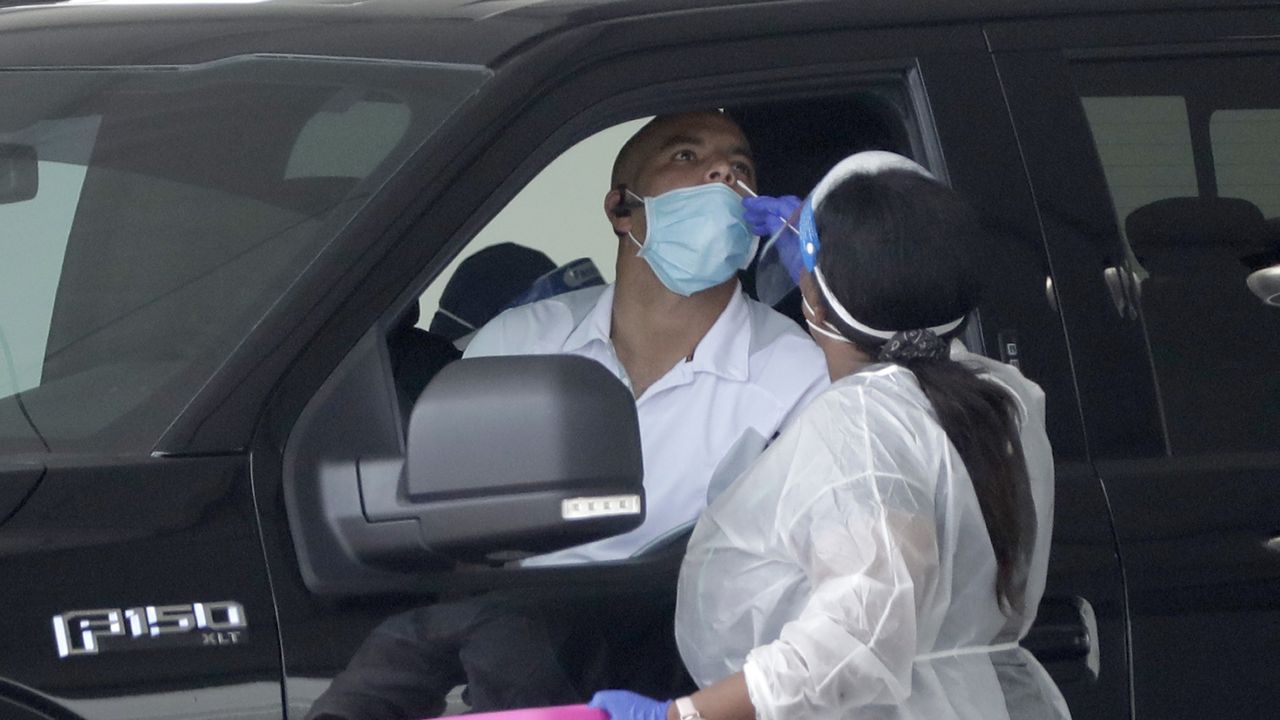 FILE: A healthcare worker performs an antigen test, Wednesday, Aug. 5, 2020, at a COVID-19 testing site in Miami Gardens, Fla. (AP Photo/Wilfredo Lee)