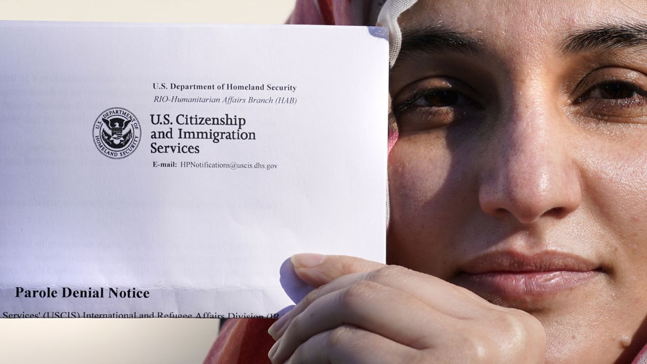 Haseena Niazi, a 24-year-old from Afghanistan, holds a parole denial notice she received from the Department of Homeland Security Friday, Dec. 17, 2021. (AP Photo/Charles Krupa)