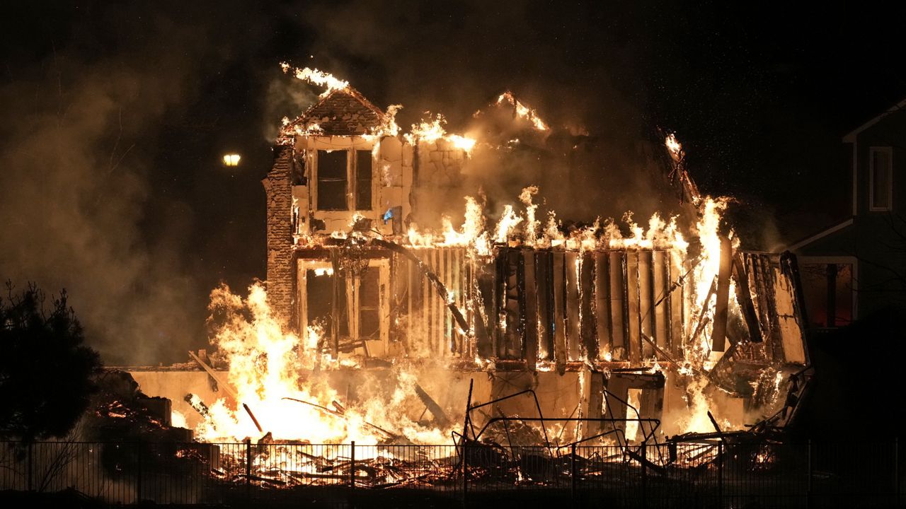 Homes burn as a wildfire rips through a development near Rock Creek Village, Thursday, Dec. 30, 2021, near Broomfield, Colo. (AP Photo/David Zalubowski)