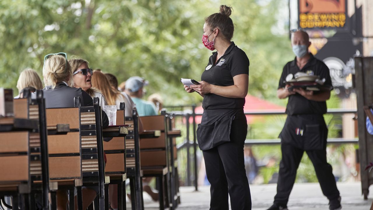 A server with a face mask takes an order at the Spaghetti Works restaurant in downtown Omaha, Neb. (via Associated Press)