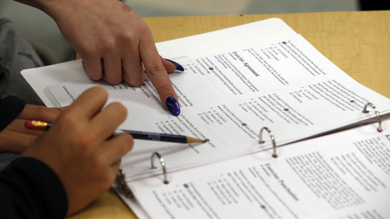 FILE: An educator points on a student's worksheet during a test preparation class at Holton Arms School, Sunday, Jan. 17, 2016 in Bethesda. (AP Photo/Alex Brandon)
