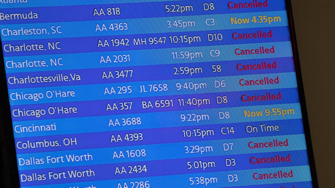 The arrivals board at the American Airlines terminal at LaGuardia Airport displays the flights that have been canceled or delayed and one that is on time, March 21, 2020, in New York. (AP Photo/Mary Altaffer, File)