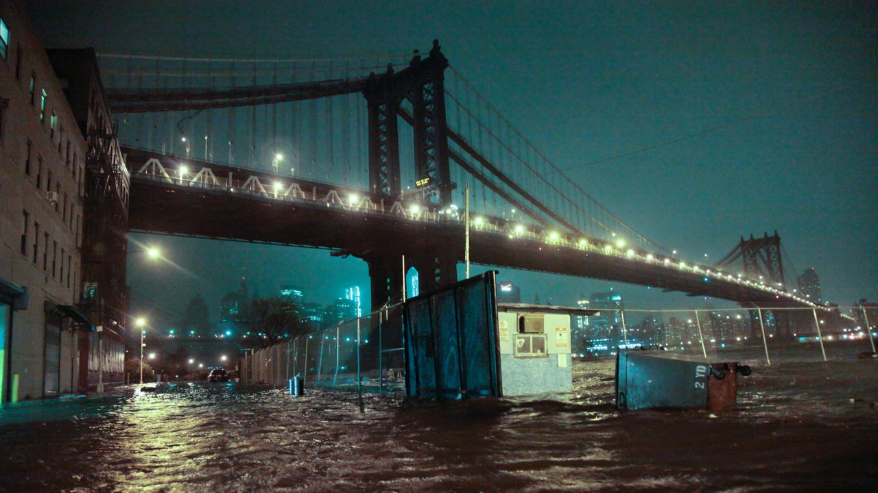 Seawater pushed onto the streets below the Manhattan Bridge during Superstorm Sandy, October 29, 2012. (AP Photo/Bebeto Matthews, File)