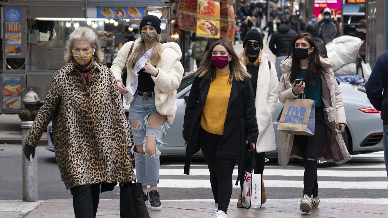 Women carry shopping bags on Dec. 10 in New York. (AP Photo/Mark Lennihan)