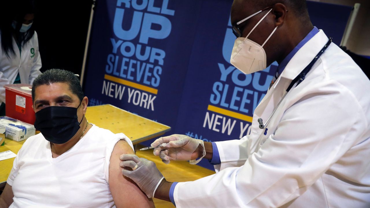 Eugenio Brito, president of Bodegas of America, receives his vaccine shot at a pop-up site in Harlem. April 23, 2021.  (Mike Segar/Pool Photo via AP)
