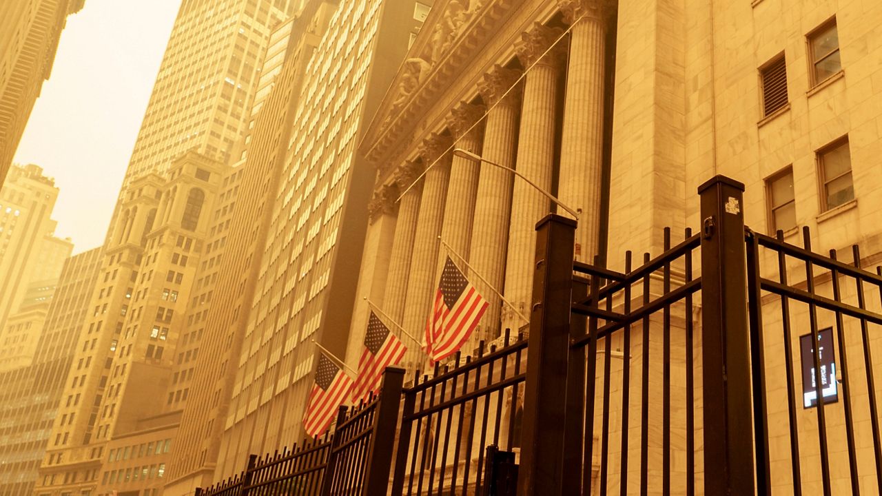 A pedestrian walks past the smoke and haze shrouded New York Stock Exchange building in New York City Wednesday, June 7, 2023.