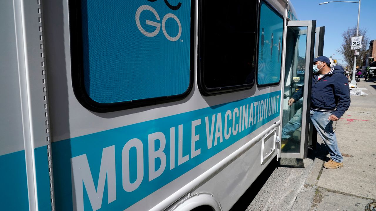 A man enters a mobile vaccination bus in Sunset Park, Brooklyn, in March. (AP Photo/Kathy Willens)