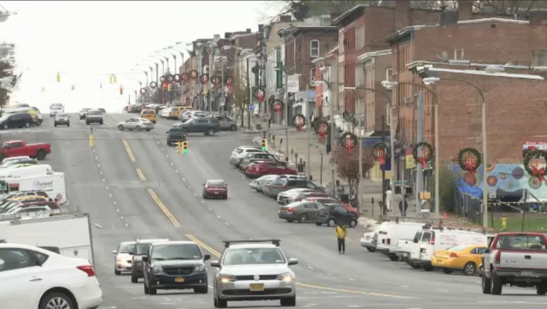 newburgh city street with cars driving toward camera, and wreaths lining streetlights