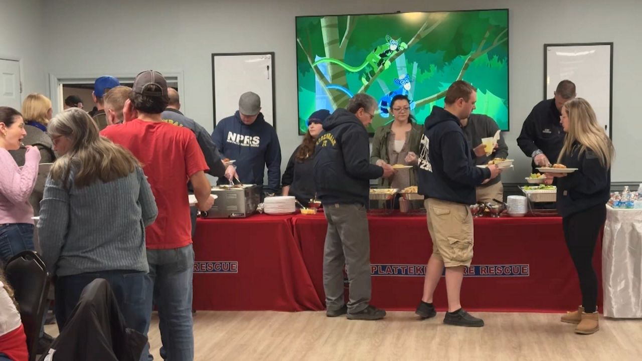 people in buffet table line at fundraiser