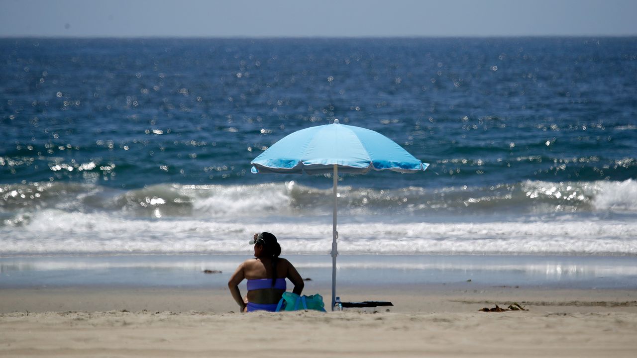 A lone beachgoer takes a sunbath Sunday, May 3, 2020, in Newport Beach, Calif. Beaches were mostly empty over the warm weekend as Californians heeded stay-at-home orders in anticipation that Gov. Gavin Newsom might ease some restrictions this week. (AP Photo/Marcio Jose Sanchez)