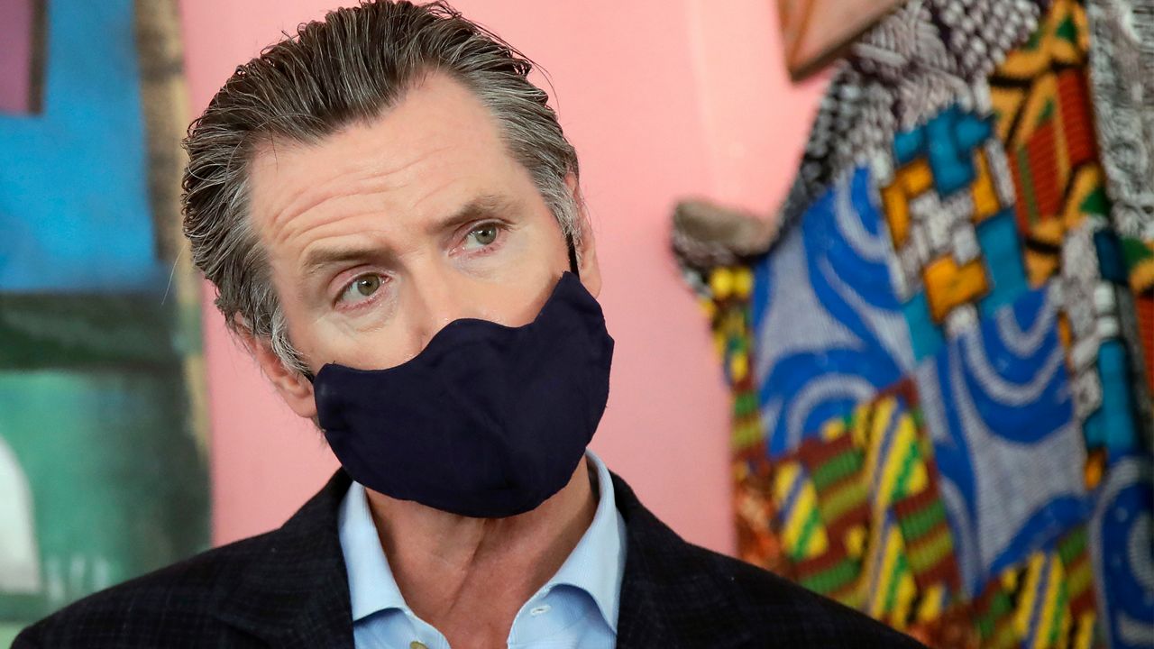 In this June 9, 2020, file photo, California Gov. Gavin Newsom wears a protective mask on his face while speaking to reporters at Miss Ollie's restaurant during the coronavirus outbreak in Oakland, Calif. Gov. Newsom's administration on Thursday, June 18, 2020, mandated that Californians wear masks in most indoor settings as the state continues to battle the coronavirus.(AP Photo/Jeff Chiu, Pool, File)