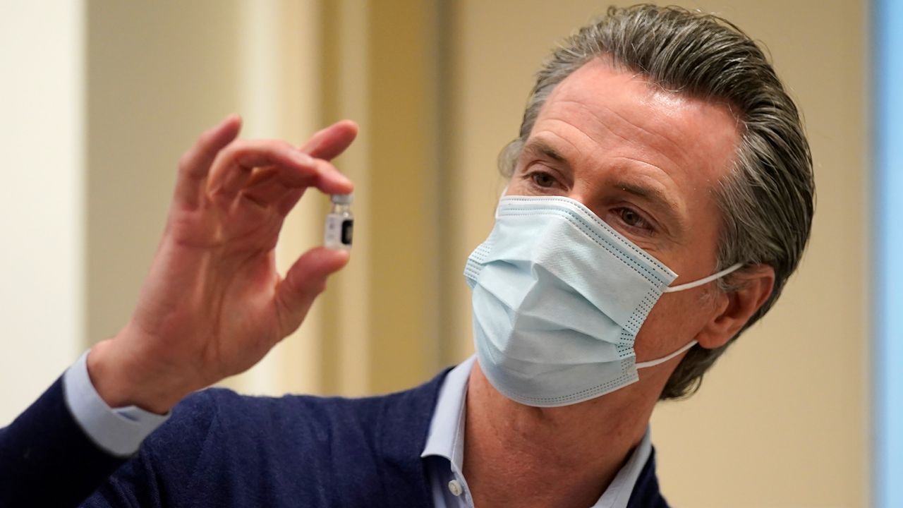  In this Dec. 14, 2020, file photo, California Gov. Gavin Newsom holds up a vial of the Pfizer-BioNTech COVID-19 vaccine at Kaiser Permanente Los Angeles Medical Center in Los Angeles. (AP Photo/Jae C. Hong, File)
