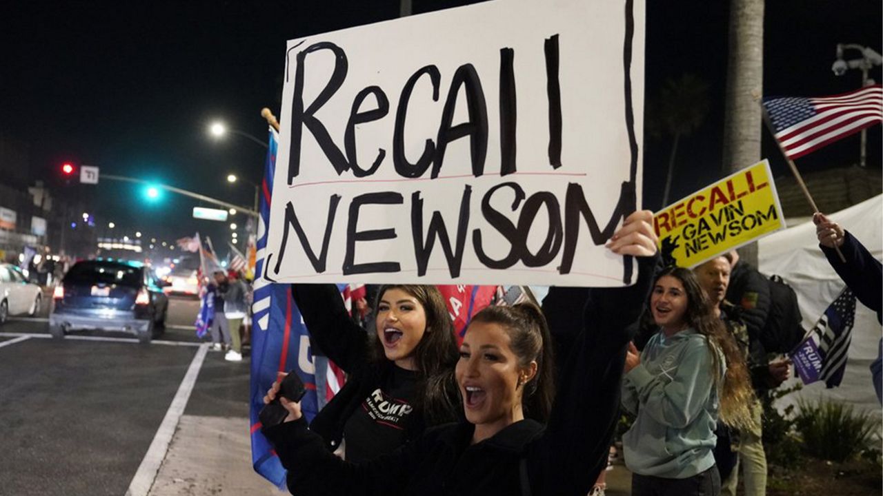 Demonstrators shout slogans while carrying a sign calling for a recall on Gov. Gavin Newsom during a protest against a stay-at-home order amid the COVID-19 pandemic in Huntington Beach, Calif. on Nov. 21, 2020. (AP Photo/Marcio Jose Sanchez)