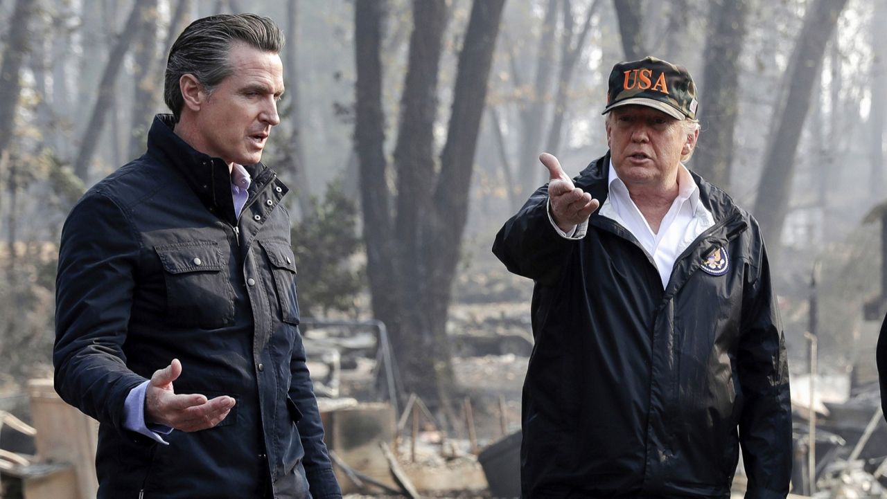 President Donald Trump talks with then California Gov.-elect Gavin Newsom, left, during a visit to a neighborhood impacted by the wildfires in Paradise, Calif. on Nov. 17, 2018. (AP Photo/Evan Vucci)