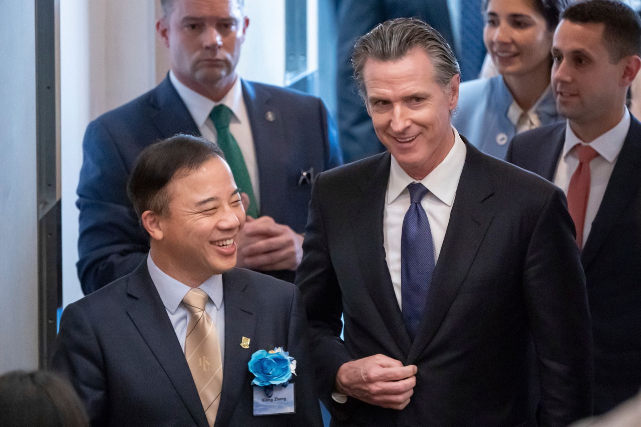Visiting California Gov. Gavin Newsom, right, and President and Vice-Chancellor of the University of Hong Kong Xiang Zhang, left, arrive at the fireside chat at the Hong Kong University in Hong Kong on Monday. (AP Photo/Anthony Kwan)
