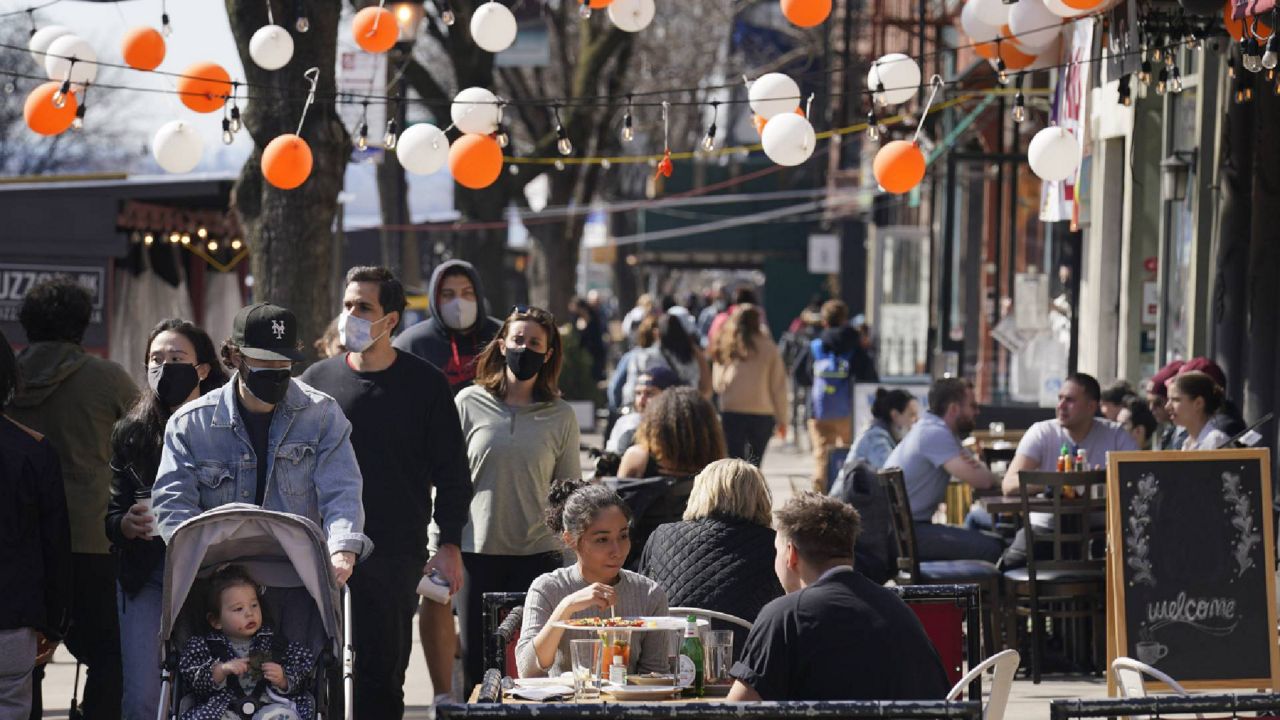 FILE - In this March 21, 2021, file photo pedestrians enjoy the sunny weather in the Brooklyn borough of New York. (AP Photo/Seth Wenig, File)