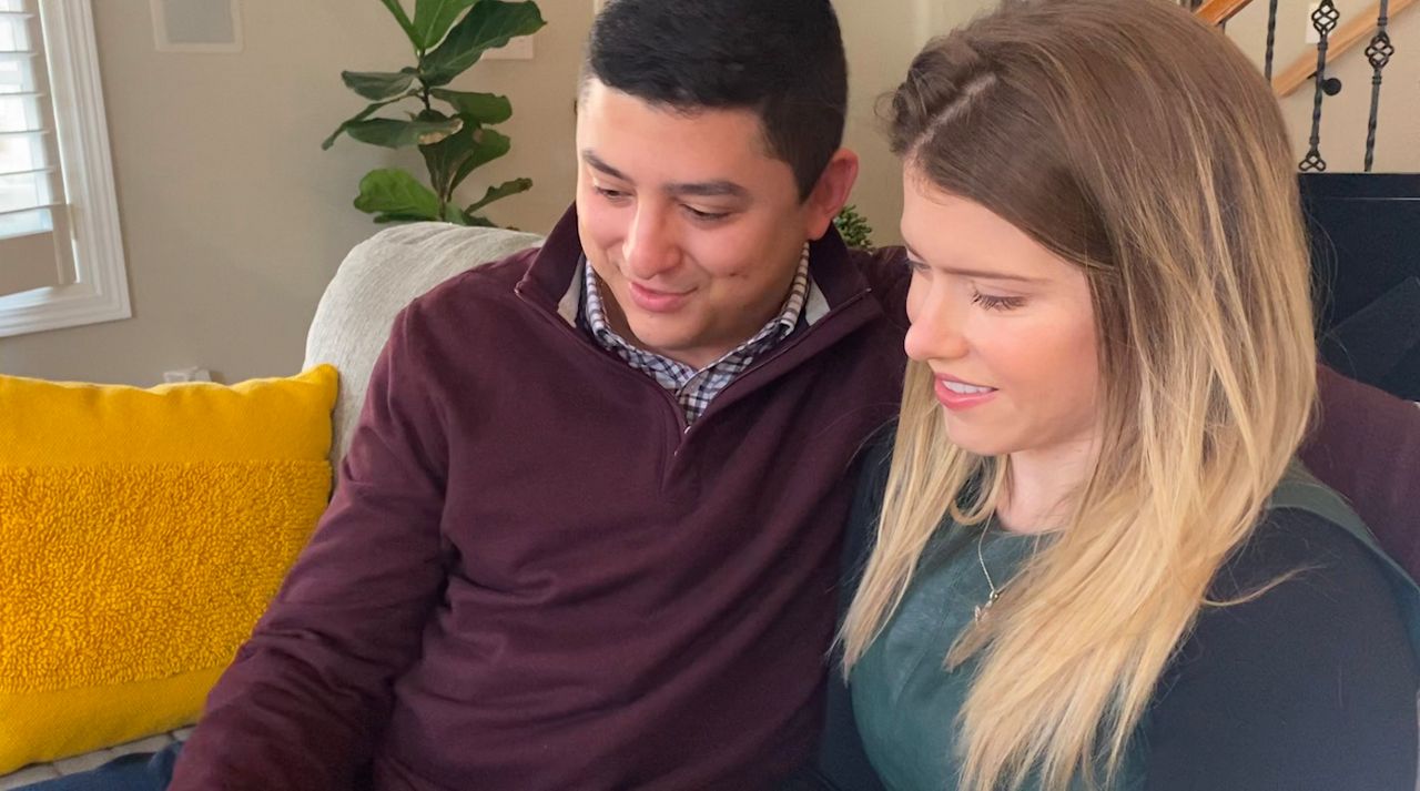 McKinnon Galloway and her fiancé Brandon Kwiatek look at pictures from their relationship. (Madison Elliott/Spectrum News 1)