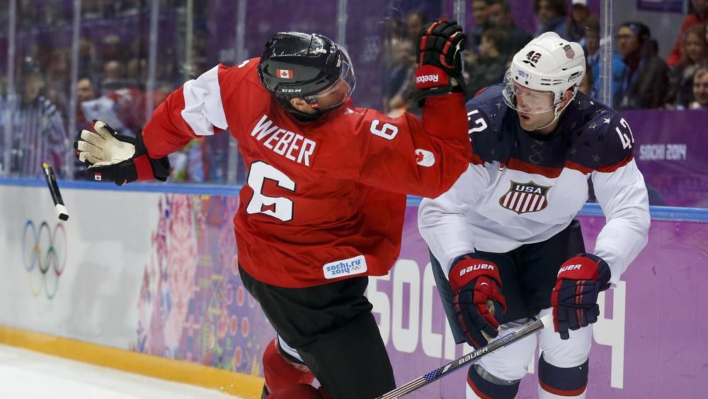 Canada defenseman Shea Weber, left, trips over USA forward David Backes during the third period of a men's semifinal ice hockey game at the 2014 Winter Olympics, Friday, Feb. 21, 2014, in Sochi, Russia. (AP Photo/Julio Cortez, File)