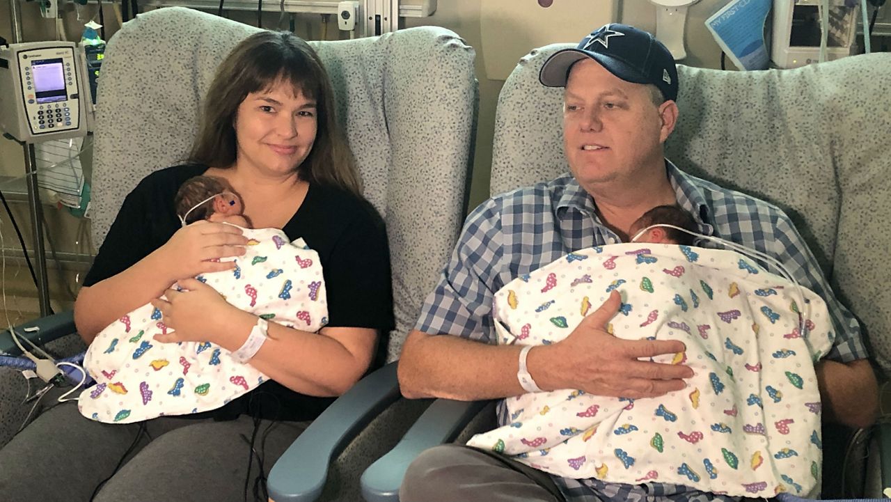 Jennifer and Preston Moses holding their daughters, Pasley and Piper. (Spectrum News)