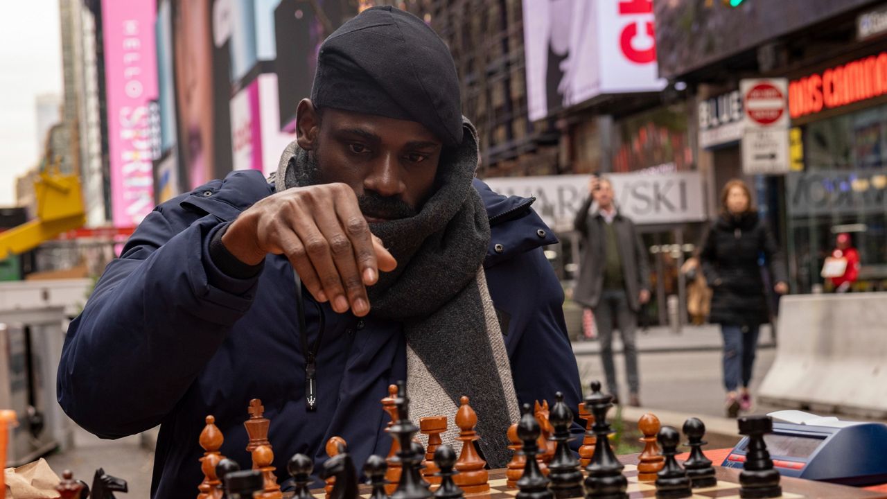 Tunde Onakoya, 29, is a Nigerian chess champion and child education advocate. In this photo, he is pictured playing chess in Times Square.