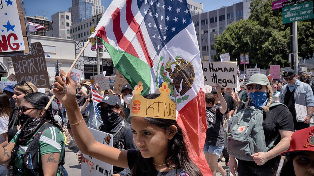A young protester carries a combination Mexican and U.S. flag during a 