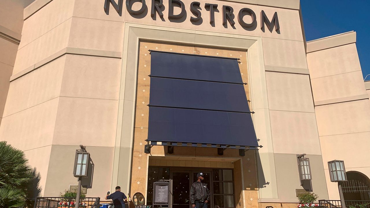 A security guard stands outside the Nordstrom store at The Grove retail and entertainment complex in Los Angeles, Tuesday, Nov. 23, 2021. 