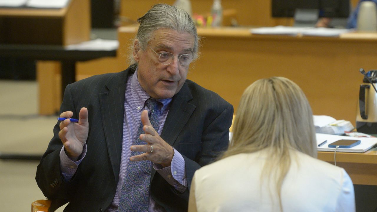 Norman Pattis, attorney for Alex Jones, in discussion with Brittany Paz, a Connecticut lawyer hired by Jones to testify about his companies' operations, during the Alex Jones Sandy Hook defamation damages trial in Superior Court in Waterbury, Conn.,, Friday, Sept. 16, 2022. (H John Voorhees III/Hearst Connecticut Media via AP, Pool)