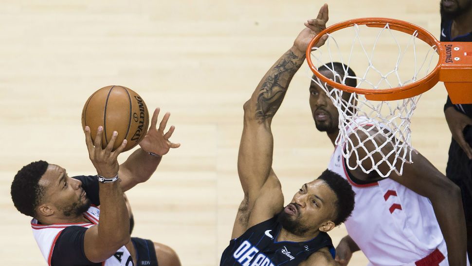 Toronto Raptors forward Norman Powell, left, drives to the net against Orlando Magic center Khem Birch (24) during the second half in Game 5 of a first-round NBA basketball playoff series, Tuesday, April 23, 2019 in Toronto. (Nathan Denette/Canadian Press via AP)