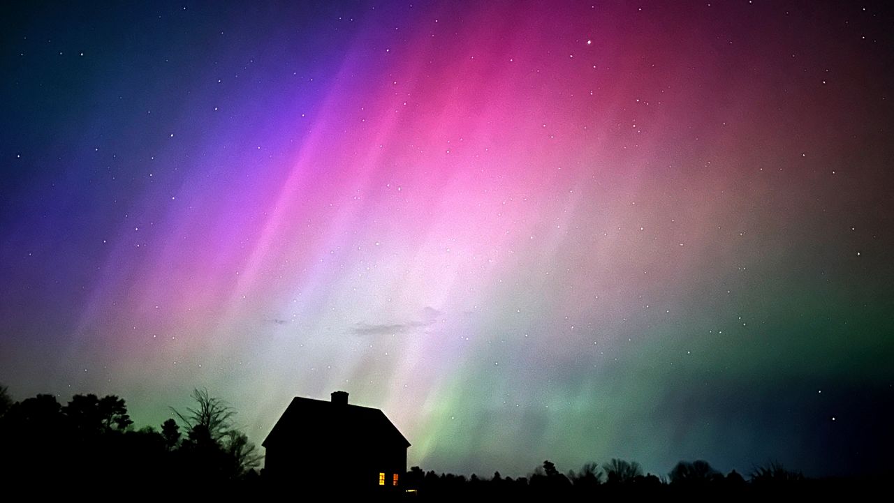 The northern lights flare in the sky over a farmhouse, late Friday, May 10, 2024, in Brunswick, Maine. (AP Photo/Robert F. Bukaty)