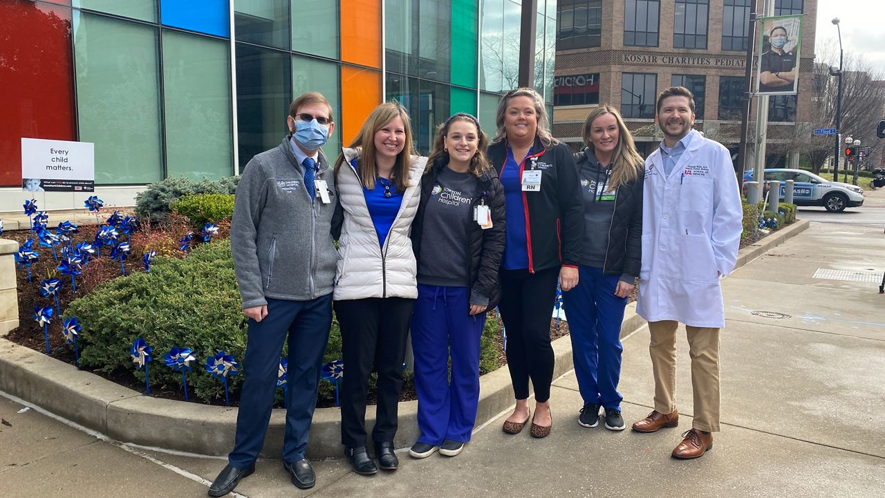 Norton Children's Hospital employees and community members spent Friday morning planting pinwheels to spread awareness about child abuse. (Spectrum News 1/Ashley N. Brown)