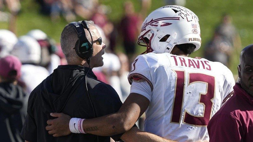 Florida State head coach Mike Norvell, left, talks with quarterback Jordan Travis (13) during the second half of an NCAA college football game against Wake Forest in Winston-Salem, N.C., Saturday, Oct. 28, 2023. (AP Photo/Chuck Burton)