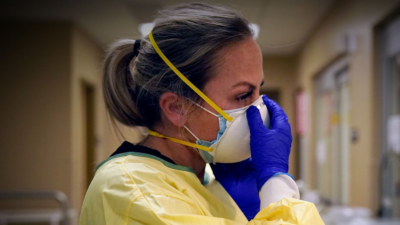 Nurse putting on PPE