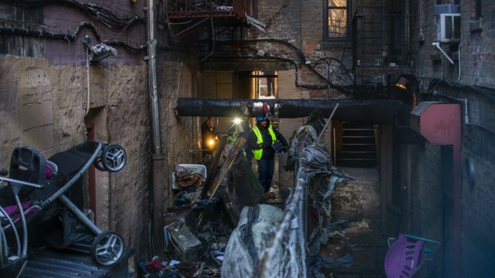 Police and workers inspect the building Friday, Dec. 29, 2017, where more than 10 people died in a fire in the Bronx borough of New York. New York City's deadliest residential fire in decades was accidentally lit by a 3 1/2-year-old boy playing with the burners on his mother's stove, officials said Friday. (AP Photo/Andres Kudacki)