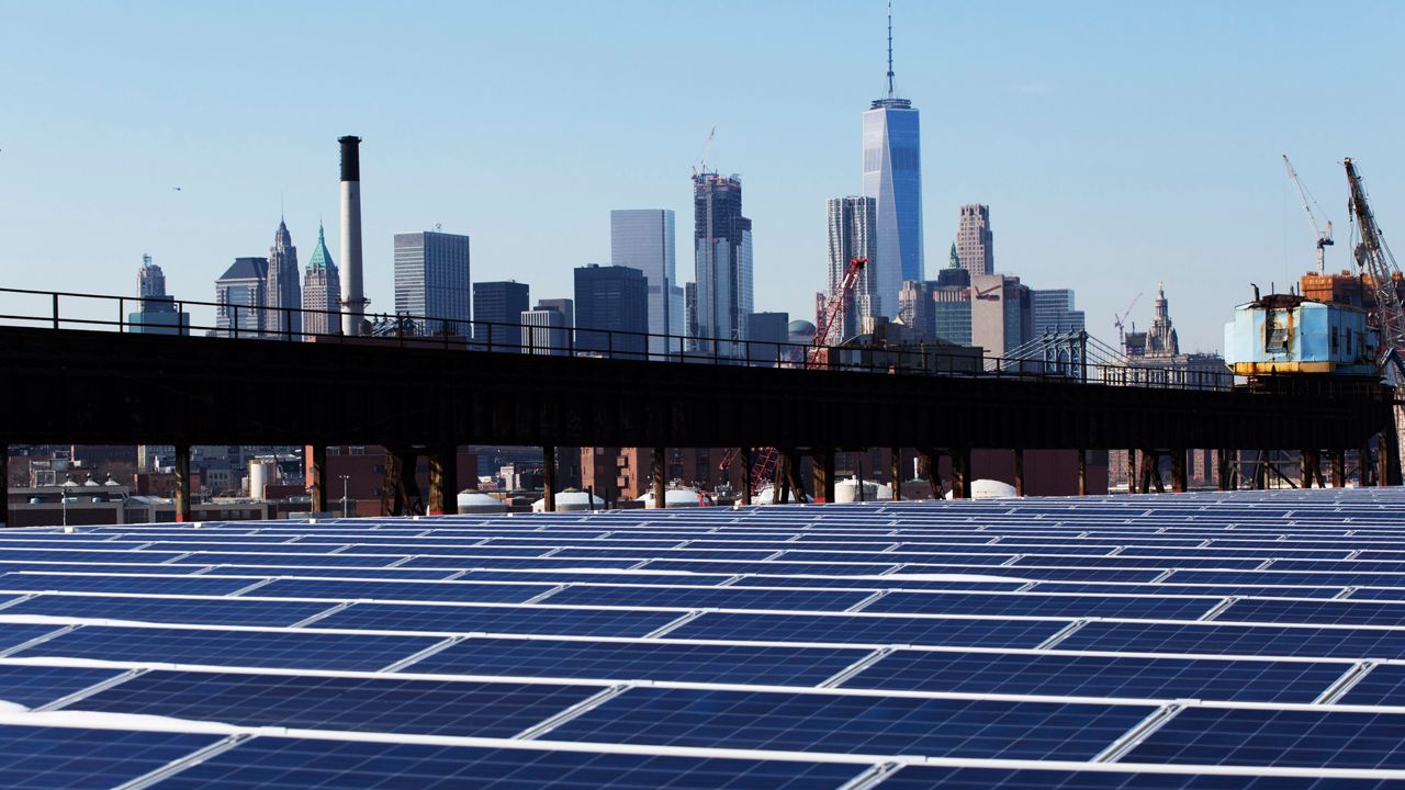 In this Feb. 14, 2017 photo, a rooftop is covered with solar panels at the Brooklyn Navy Yard in New York. The Manhattan skyline is at top. Even if President Donald Trump withdraws U.S. support for the Paris climate change accord, domestic efforts to battle global warming will continue. Dozens of states and many cities have policies intended to reduce emissions of greenhouses gases and deal with the effects of rising temperatures. Even in red states, many consider flood prevention and renewable energy are considered smart business. (AP Photo/Mark Lennihan)